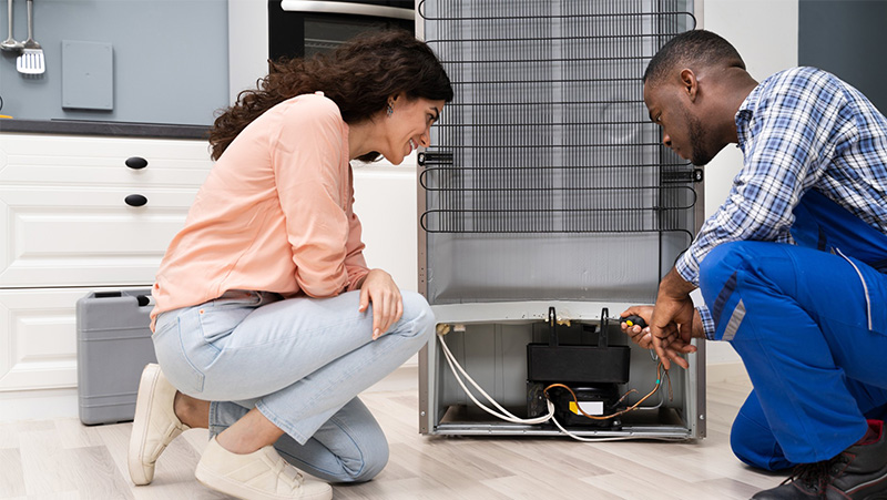 Man and Women Check Refrigerator Compressor